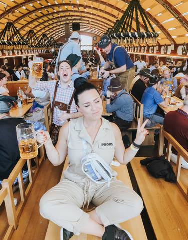 A woman enjoying a beer inside an Oktoberfest tent.