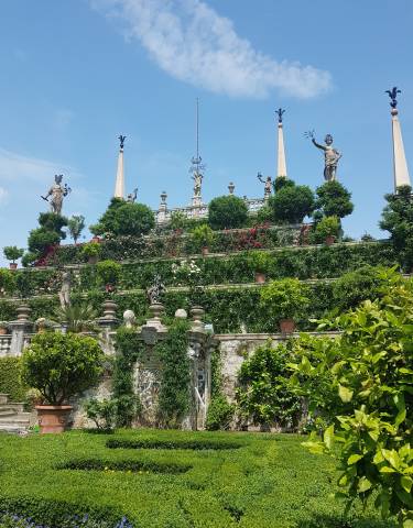 Terraced garden with statues and lush greenery.