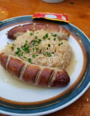 Traditional sausages with sauerkraut on a plate.