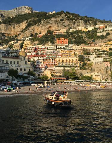 View of Positano with colorful houses on the hillside near the beach.