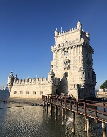 Beautiful tower with intricate architecture by a waterfront.