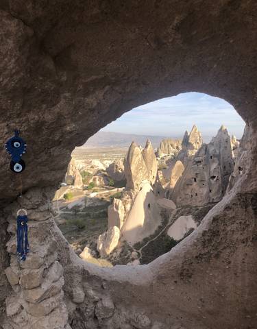 Sunlit rocky formations in Cappadocia from a cave perspective.