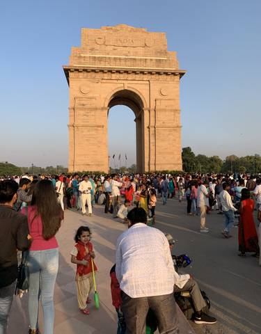 Large crowd gathering at an iconic stone arch monument.