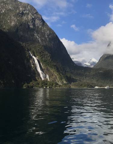 Waterfall cascading down a lush green mountain.