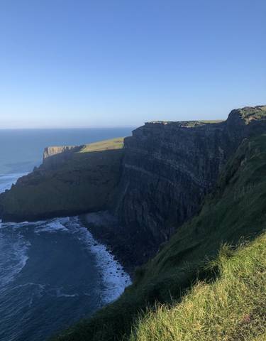Cliffs of Moher with blue ocean and sky.