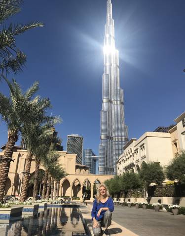 Tall skyscraper with palm trees in foreground.