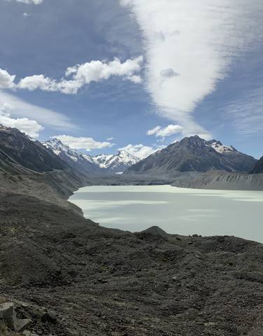 A breathtaking view of a glacier-fed lake surrounded by snow-capped mountains.