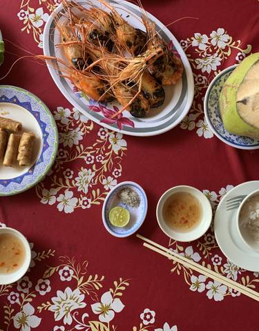 Vietnamese dishes arranged on a table with decorative cloth.