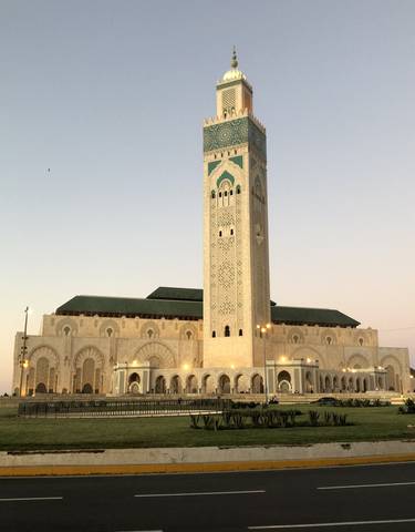 Tall minaret of a grand mosque at sunset.