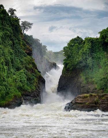 Waterfall cascading between lush green cliffs.