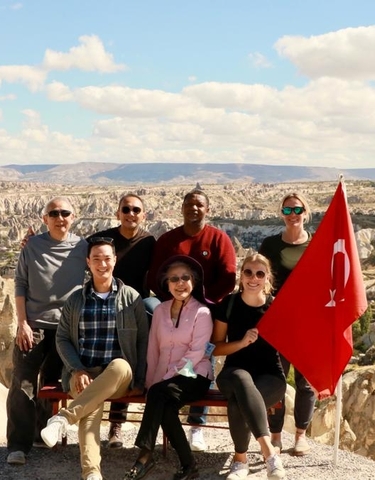 Group of people with a Turkish flag overlooking Cappadocia.