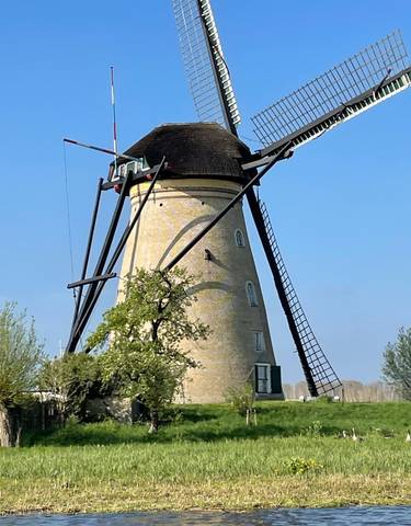 Traditional windmill with a clear blue sky background.