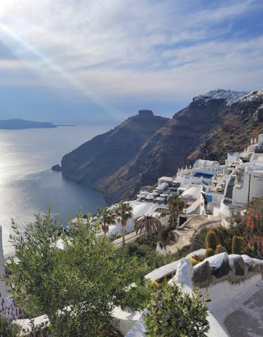 Santorini-style buildings on a cliff overlooking the sea.