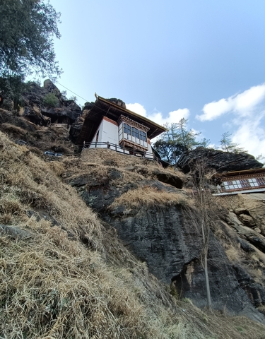 Traditional Bhutanese building integrated into a cliffside.