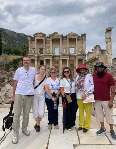 Tourists posing in front of ancient ruins.