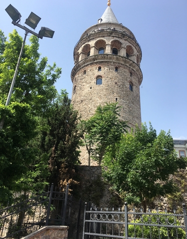 Stone tower surrounded by green trees.