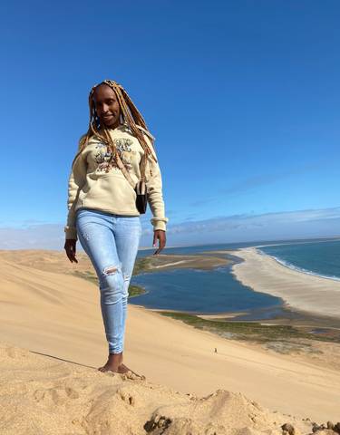 Smiling woman in the desert near the coast.