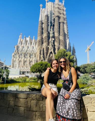 Two people smiling in front of a famous cathedral.