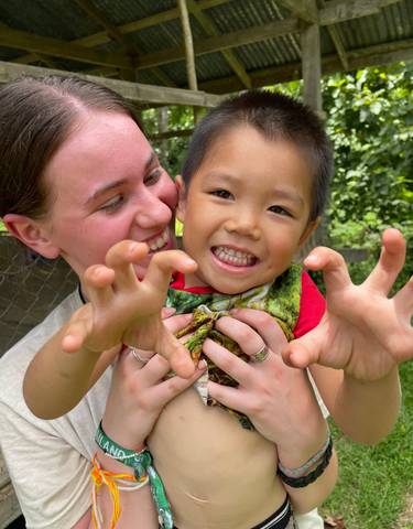 Young woman hugging and playfully interacting with a child.
