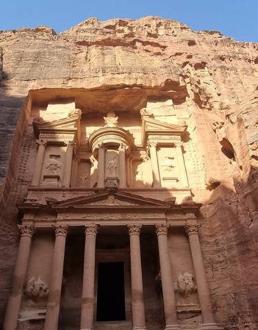Ancient stone building facade with columns and intricate carvings.