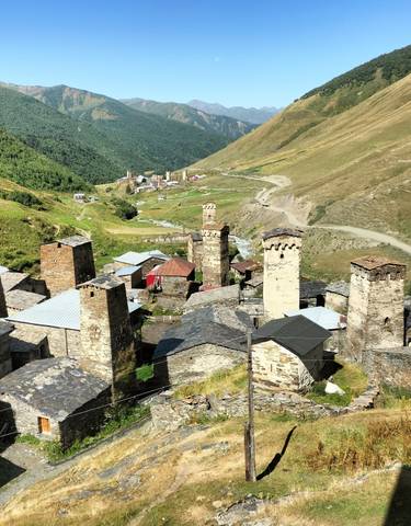 Historic village with several towers in a mountain landscape.