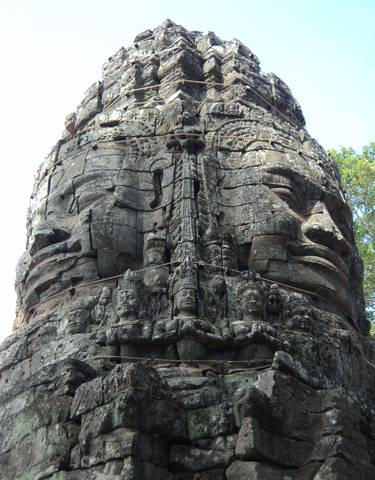 Intricate stone carvings of faces on a temple ruin.
