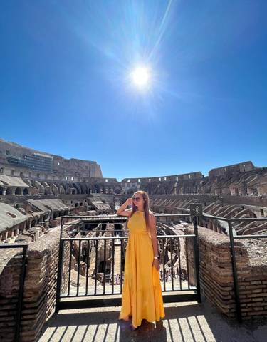 Woman posing inside the Colosseum with bright sunlight.