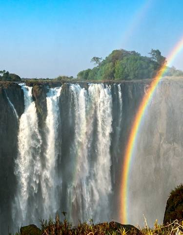 Victoria Falls with a double rainbow above the waterfall.