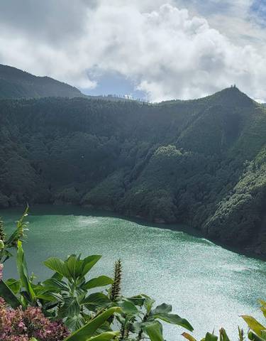 Lush green hills surrounding an emerald lake.