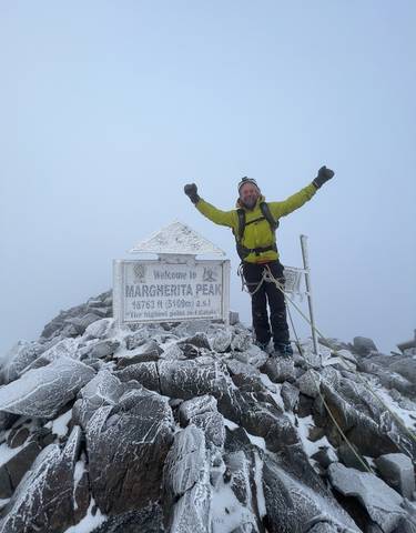 A climber celebrating on a snowy peak.
