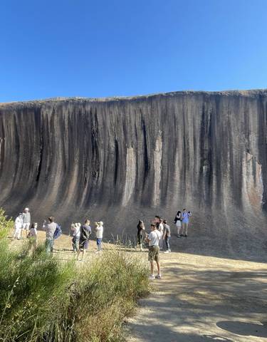 People exploring Wave Rock in Australia.