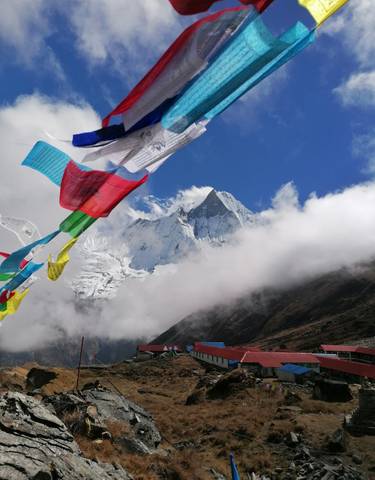 Prayer flags with a striking view of a snow-capped mountain.