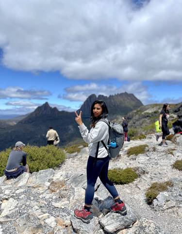 Person posing with mountains in the background