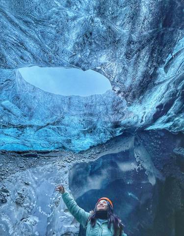 Interior view of an ice cave with blue ice walls.