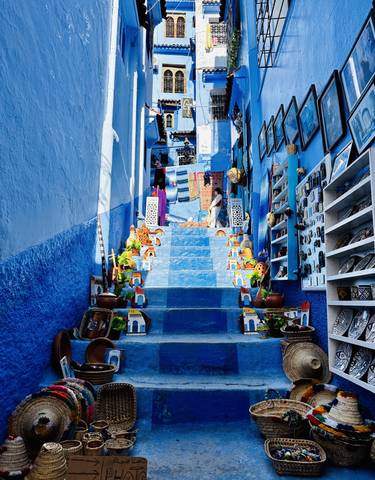 Blue-painted steps with local crafts in Chefchaouen.