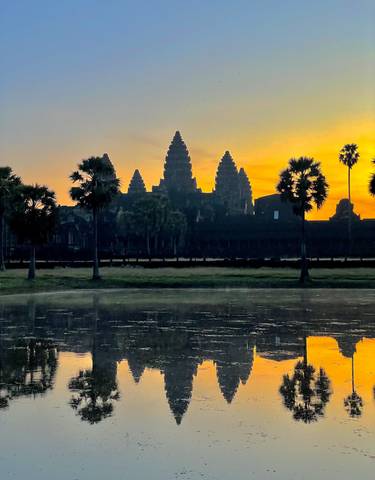 Angkor Wat silhouetted against a vibrant sunset.