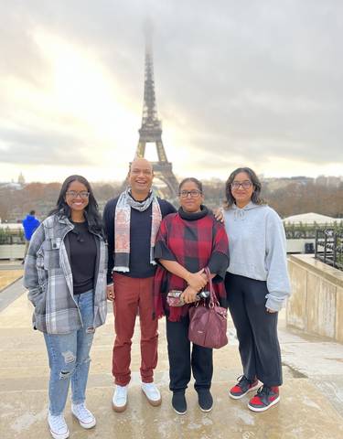 Family posing in front of the Eiffel Tower.