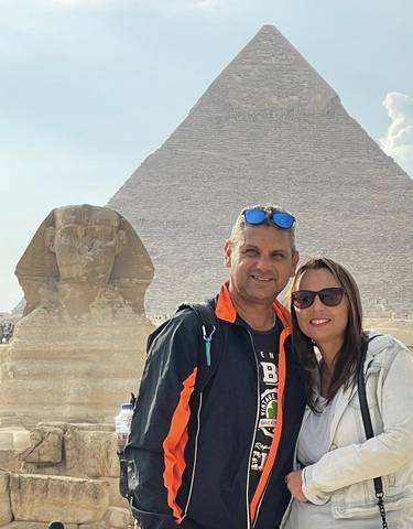 A couple posing in front of the Sphinx and a pyramid at Giza.