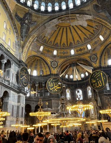 Interior view of a grand dome with ornate decorations and lights.