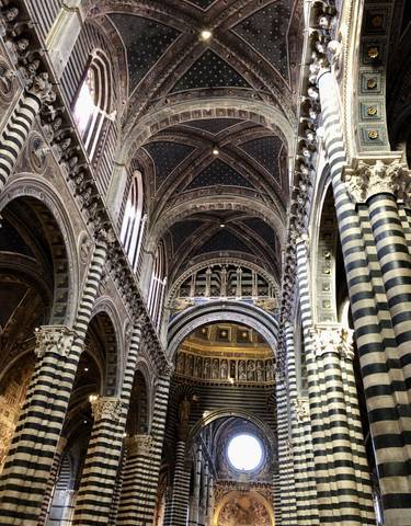Cathedral interior with striped columns and vaulted ceilings.