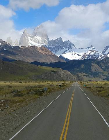 Long road leading towards snowy mountains.