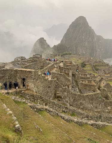 Machu Picchu ruins with tourists exploring.