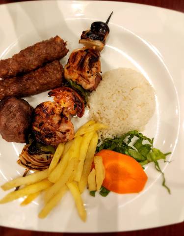 Plate of Middle Eastern grilled food with rice.