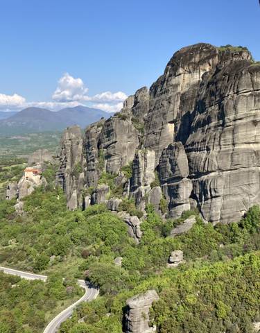 Dramatic rock formations in a lush green landscape.
