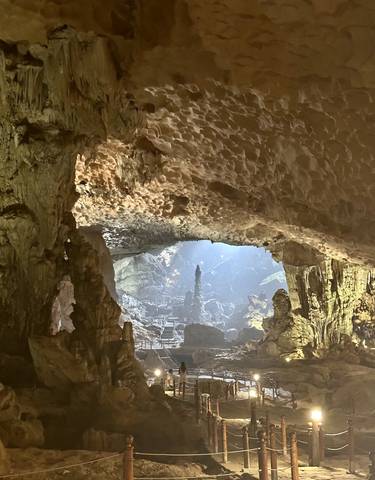 Illuminated cave interior with stalactites.