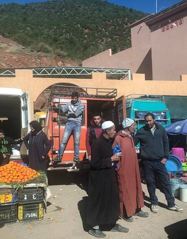 People at a market with fresh produce and goods.