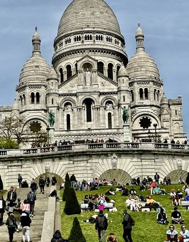 Close-up view of the Basilica of the Sacré-Cœur with people on the steps.