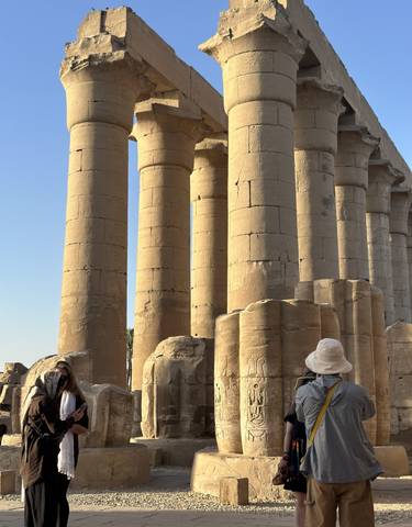 Ancient stone pillars with tourists walking around.