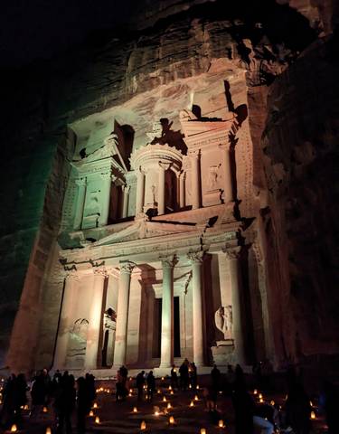 Illuminated historical monument with intricate carvings.