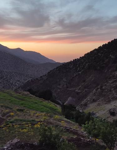 Mountain view at sunset with silhouetted peaks.